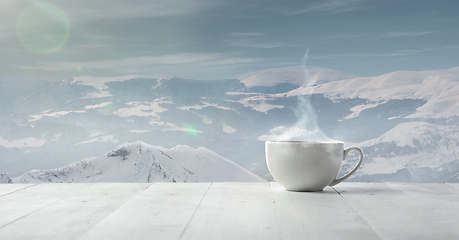 Image showing Single tea or coffee cup and landscape of mountains on background