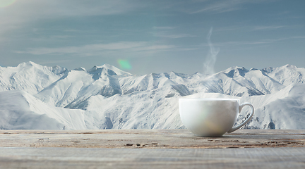 Image showing Single tea or coffee cup and landscape of mountains on background