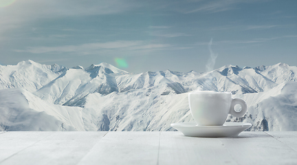 Image showing Single tea or coffee cup and landscape of mountains on background