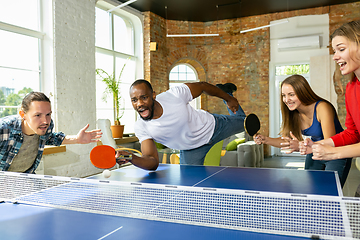 Image showing Young people playing table tennis in workplace, having fun