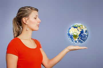 Image showing woman watching planet earth above her hand