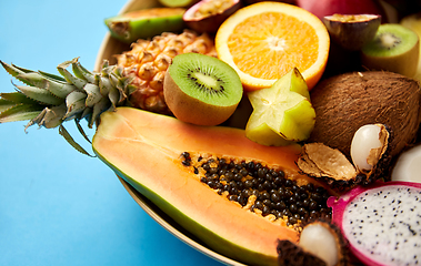 Image showing plate of exotic fruits on blue background