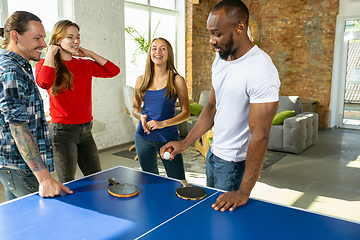 Image showing Young people playing table tennis in workplace, having fun