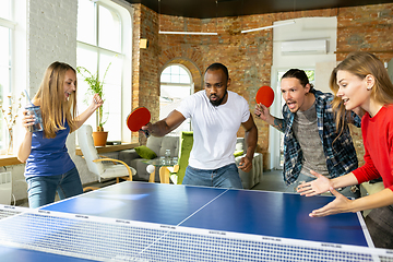 Image showing Young people playing table tennis in workplace, having fun