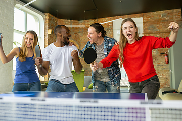 Image showing Young people playing table tennis in workplace, having fun