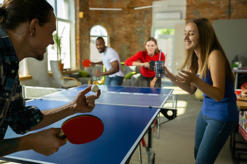 Image showing Young people playing table tennis in workplace, having fun