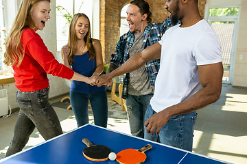 Image showing Young people playing table tennis in workplace, having fun