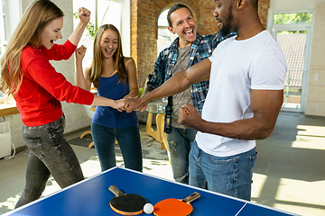 Image showing Young people playing table tennis in workplace, having fun