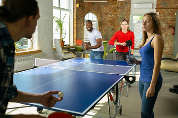 Image showing Young people playing table tennis in workplace, having fun