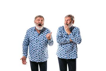 Image showing Senior man arguing with himself on white studio background.