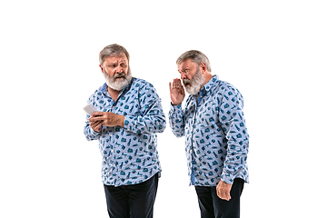 Image showing Senior man arguing with himself on white studio background.