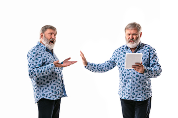 Image showing Senior man arguing with himself on white studio background.