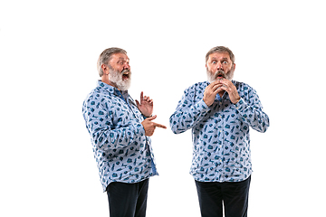 Image showing Senior man arguing with himself on white studio background.