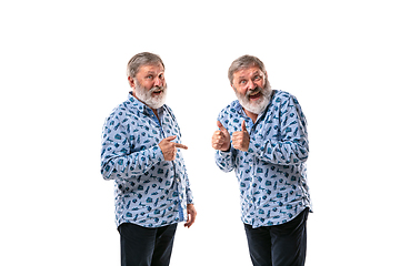 Image showing Senior man arguing with himself on white studio background.