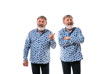 Image showing Senior man arguing with himself on white studio background.