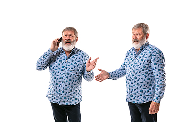 Image showing Senior man arguing with himself on white studio background.