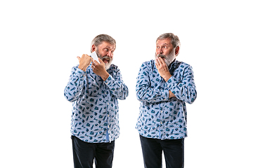 Image showing Senior man arguing with himself on white studio background.