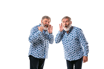 Image showing Senior man arguing with himself on white studio background.