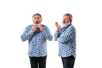 Image showing Senior man arguing with himself on white studio background.