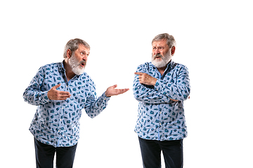 Image showing Senior man arguing with himself on white studio background.