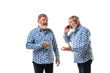 Image showing Senior man arguing with himself on white studio background.