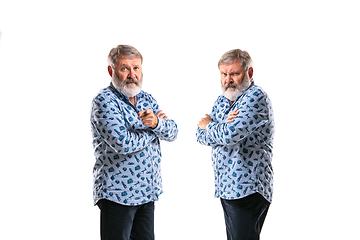 Image showing Senior man arguing with himself on white studio background.