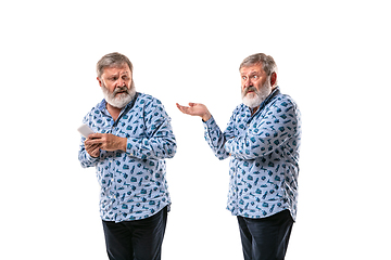 Image showing Senior man arguing with himself on white studio background.