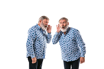 Image showing Senior man arguing with himself on white studio background.