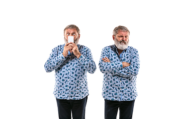 Image showing Senior man arguing with himself on white studio background.