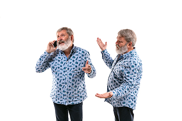 Image showing Senior man arguing with himself on white studio background.