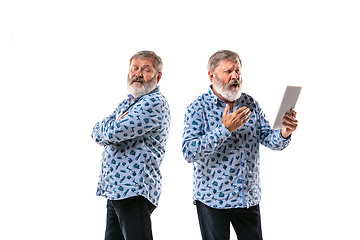 Image showing Senior man arguing with himself on white studio background.