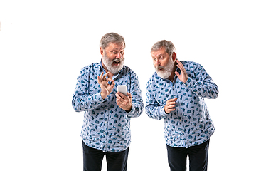 Image showing Senior man arguing with himself on white studio background.