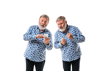 Image showing Senior man arguing with himself on white studio background.