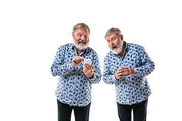 Image showing Senior man arguing with himself on white studio background.