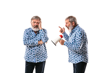 Image showing Senior man arguing with himself on white studio background.