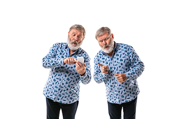 Image showing Senior man arguing with himself on white studio background.