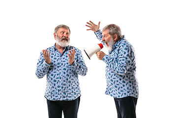 Image showing Senior man arguing with himself on white studio background.