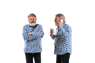 Image showing Senior man arguing with himself on white studio background.