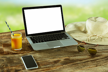 Image showing Blank laptop on a wooden table outdoors, mock up