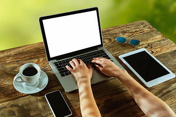 Image showing Blank laptop on a wooden table outdoors, mock up