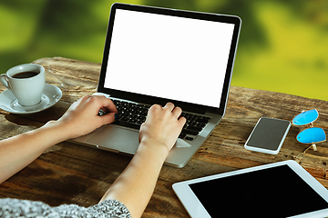 Image showing Blank laptop on a wooden table outdoors, mock up