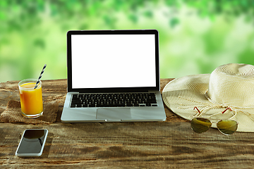 Image showing Blank laptop on a wooden table outdoors, mock up