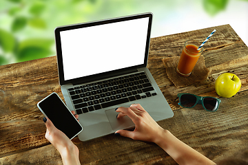 Image showing Blank laptop on a wooden table outdoors, mock up