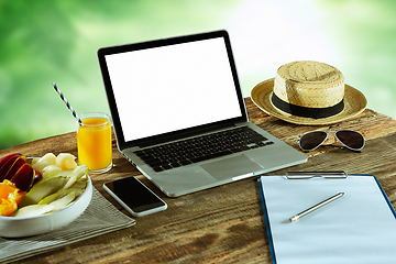 Image showing Blank laptop on a wooden table outdoors, mock up