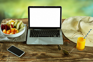 Image showing Blank laptop on a wooden table outdoors, mock up