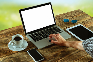 Image showing Blank laptop on a wooden table outdoors, mock up