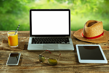 Image showing Blank laptop on a wooden table outdoors, mock up