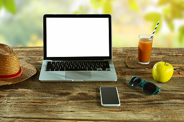 Image showing Blank laptop on a wooden table outdoors, mock up