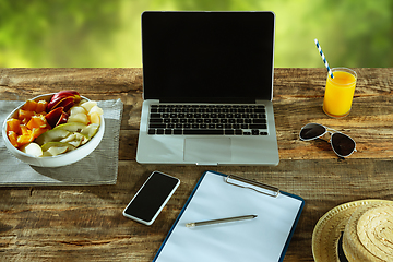 Image showing Blank laptop on a wooden table outdoors, mock up