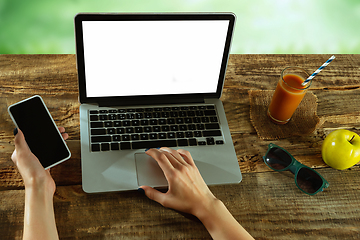 Image showing Blank laptop on a wooden table outdoors, mock up